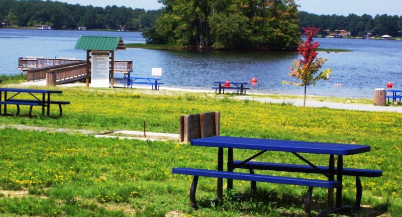park with picnic table with lake, pier, and swimming area