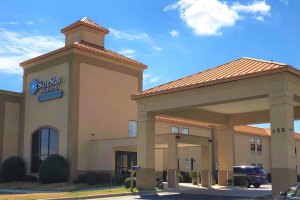 exterior of hotel showing covered entrance and sign that says SureStay plus hotel by Best Western